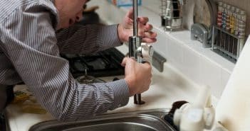 Un plombier qui répare un robinet