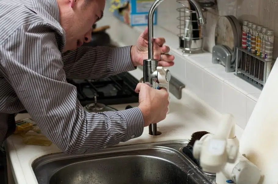 Un plombier qui répare un robinet