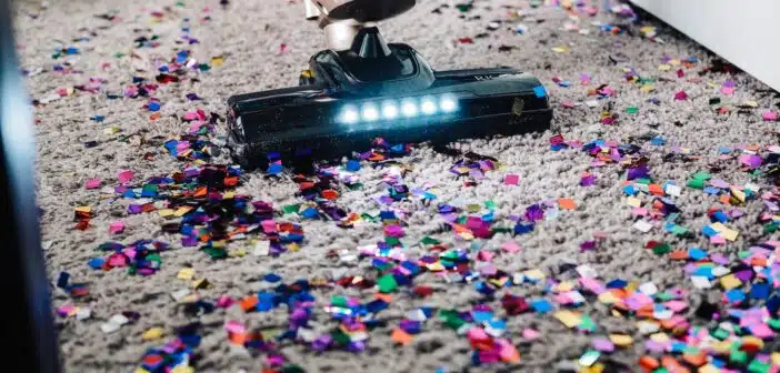 a person using a vacuum to clean a carpet