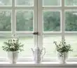 white teapot and tow flower vases on windowpane